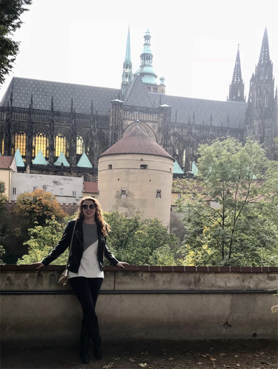 A woman stands in front of a Cathedral