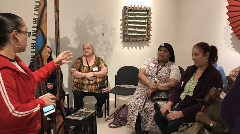 Members of the community advisory group discuss amidst artworks