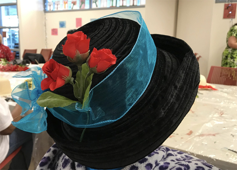 A colorful hat with blue ribbon and red roses decorated during an ARTZ event