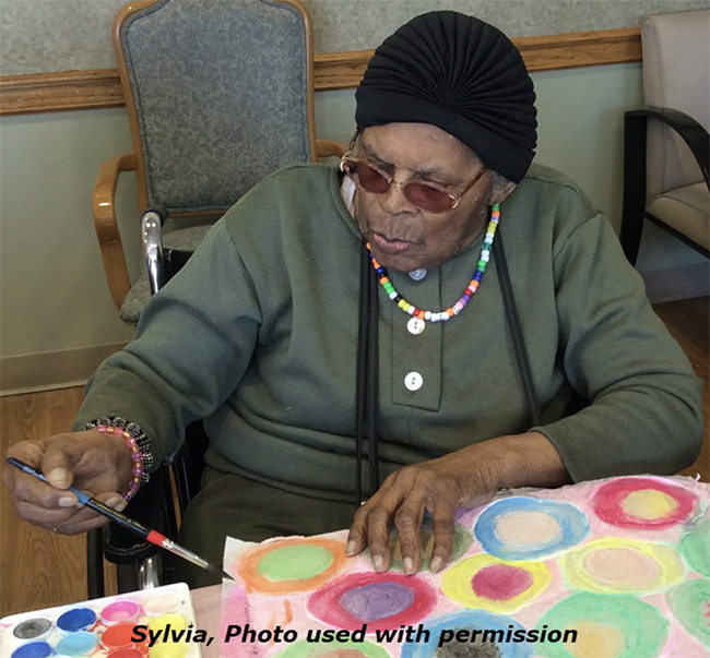 ARTZ participants Sylvia works on a painting of colorful circles