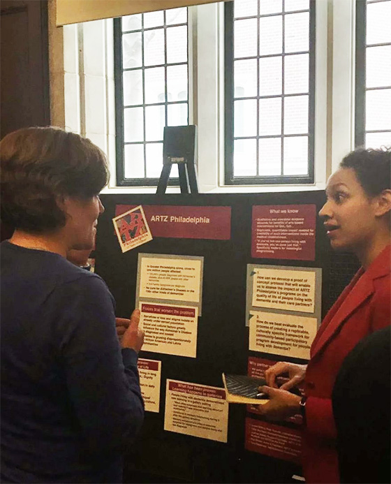 Two women discuss a booth at the research day