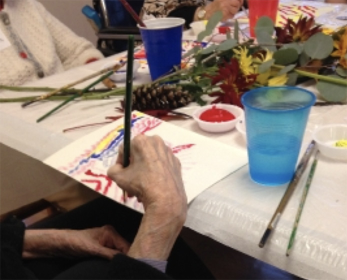 An ARTZ participant works on a colorful painting