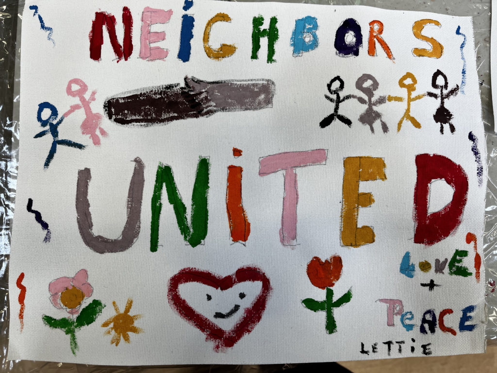 A colorful painting that reads "Neighbors United" with flowers, hearts, and stick people