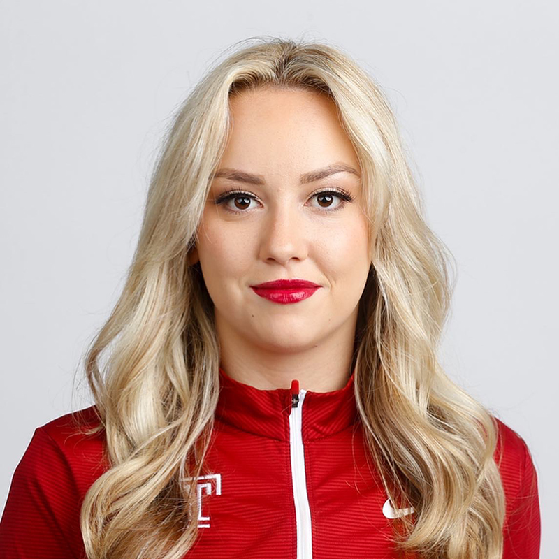 Portrait of Emily Markovich looking at the camera wearing a bright red zip up