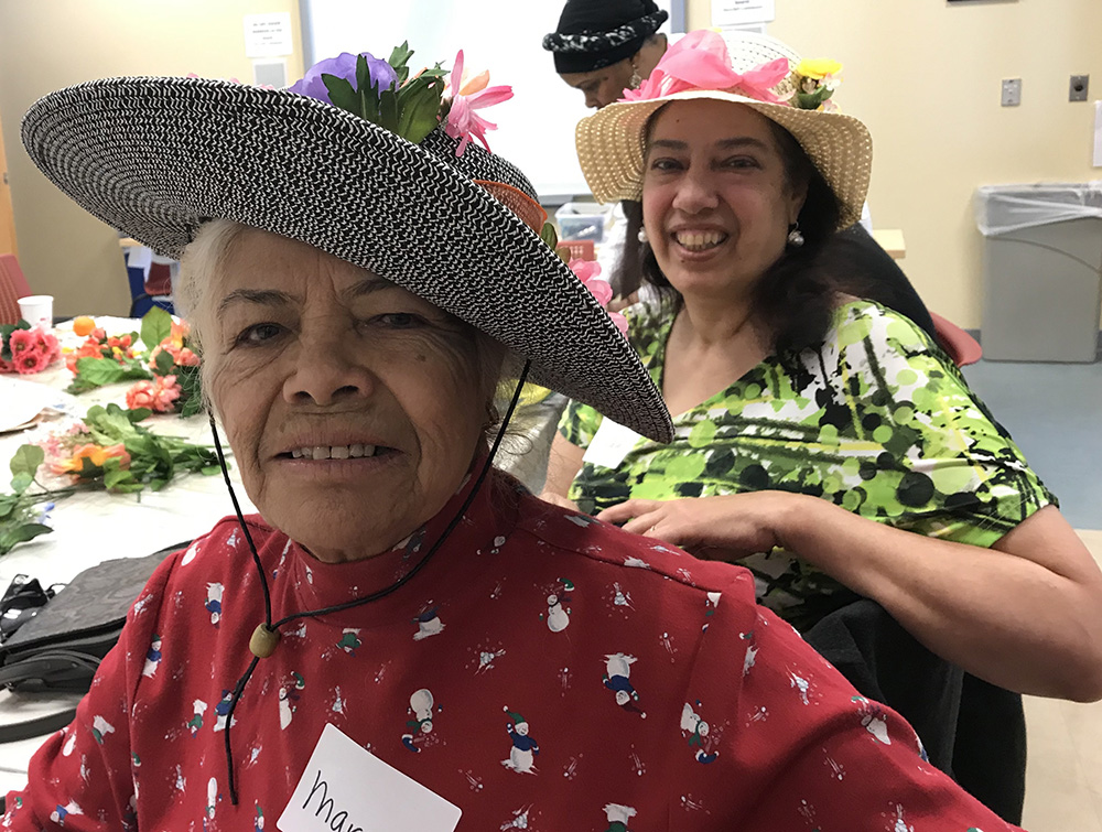 Margarita and Lillian wear colorful hats they designed at Café Para Dos